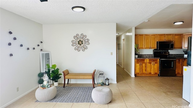 kitchen featuring light tile patterned floors, a textured ceiling, electric range, brown cabinets, and dark countertops