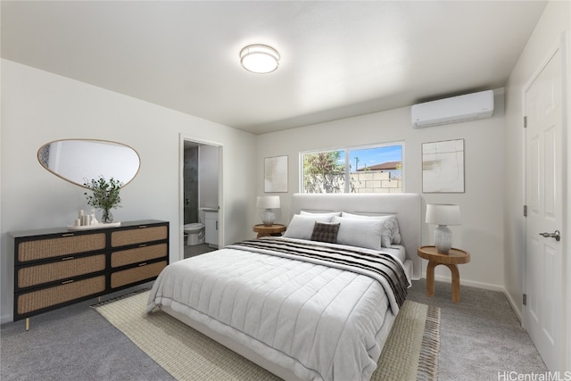 carpeted bedroom featuring a wall mounted air conditioner, connected bathroom, and baseboards