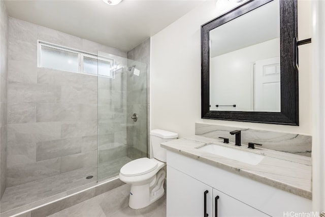 bathroom with a stall shower, toilet, and vanity