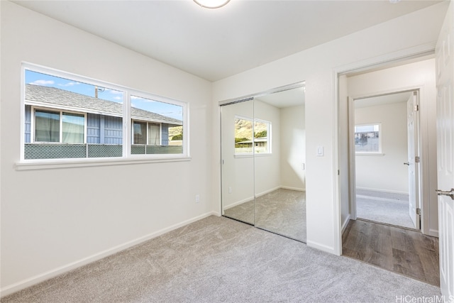 unfurnished bedroom featuring carpet flooring, baseboards, and a closet