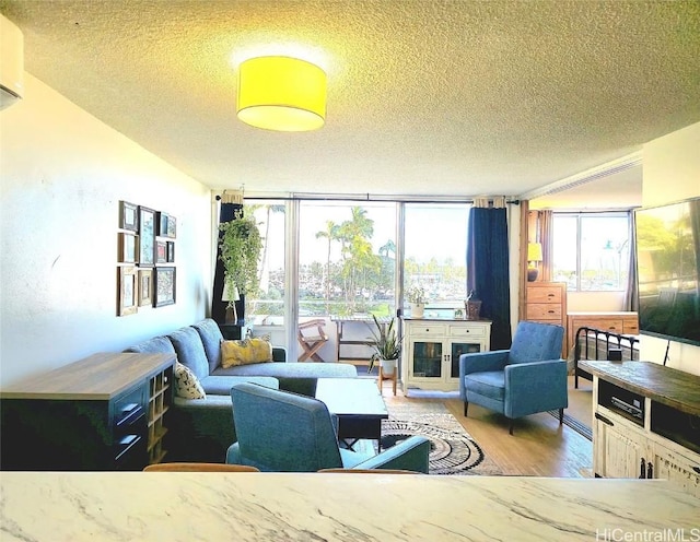 interior space featuring a textured ceiling, a wall of windows, and wood finished floors