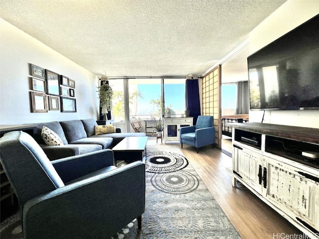 living area with a textured ceiling, wood finished floors, and floor to ceiling windows