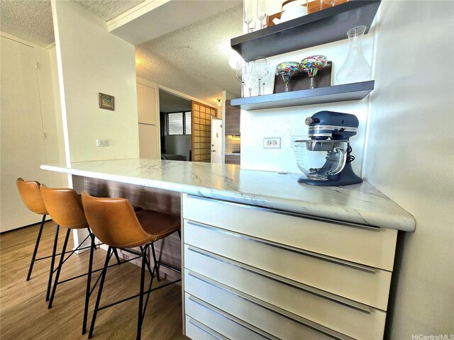 1676 Ala Moana Blvd Unit 205, Honolulu, HI 96815 - kitchen with a textured ceiling, wood finished floors, and light stone countertops