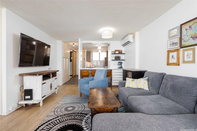 1676 Ala Moana Blvd Unit 205, Honolulu, HI 96815 - living area with a wall unit AC, light wood finished floors, and a textured ceiling