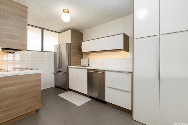 1676 Ala Moana Blvd Unit 205, Honolulu, HI 96815 - kitchen featuring stainless steel appliances, a sink, tile walls, white cabinetry, and light stone countertops
