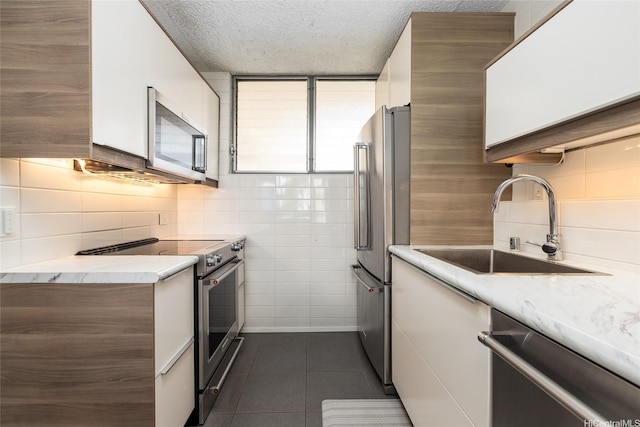 1676 Ala Moana Blvd Unit 205, Honolulu, HI 96815 - kitchen with appliances with stainless steel finishes, white cabinetry, a sink, dark tile patterned flooring, and light countertops