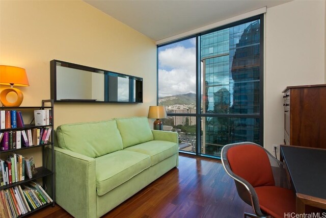 interior space with expansive windows, a mountain view, wood finished floors, and a wealth of natural light