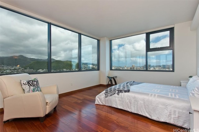 bedroom featuring wood finished floors and a mountain view