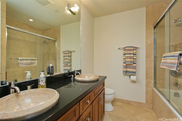 bathroom featuring double vanity, a sink, visible vents, and tile patterned floors