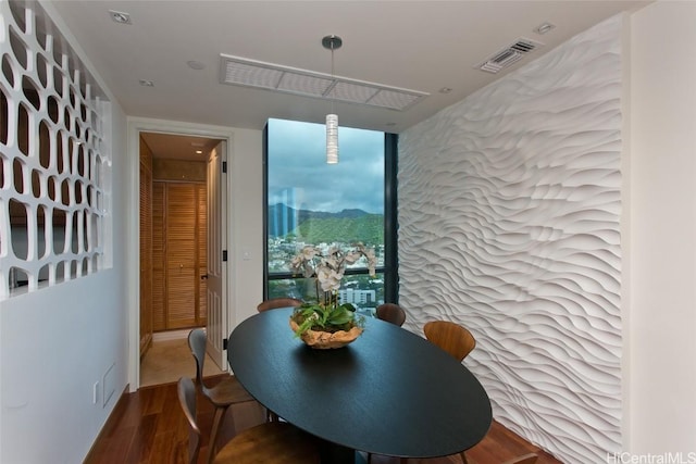 dining space with visible vents and wood finished floors