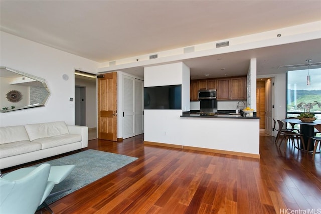 living room with dark wood-type flooring and visible vents