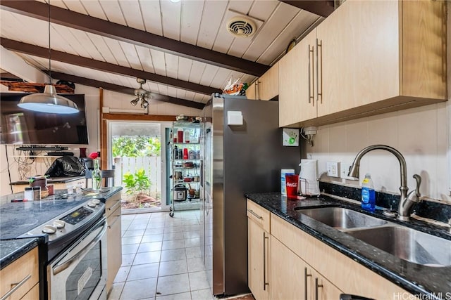 kitchen featuring light brown cabinets, a sink, visible vents, appliances with stainless steel finishes, and dark stone counters