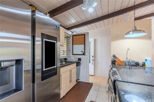 kitchen with pendant lighting, vaulted ceiling with beams, dark countertops, appliances with stainless steel finishes, and light tile patterned flooring