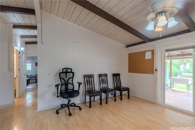 living area featuring light wood finished floors, beam ceiling, and a wealth of natural light