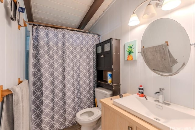 bathroom featuring curtained shower, beam ceiling, vanity, and toilet