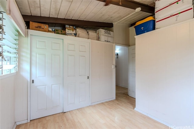 unfurnished bedroom featuring light wood-type flooring, wooden ceiling, and beamed ceiling