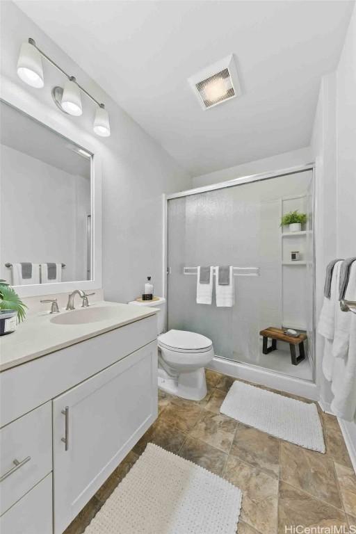 full bathroom with visible vents, a shower stall, toilet, and vanity