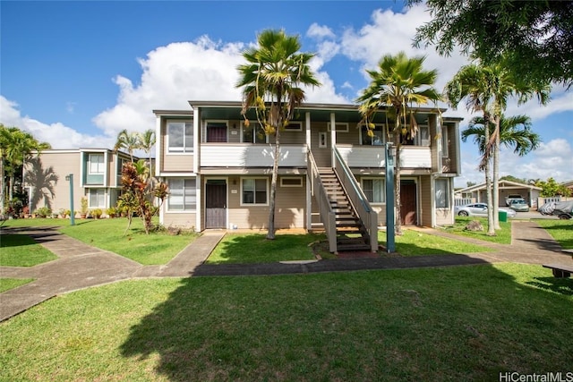 multi unit property featuring stairs and a front lawn