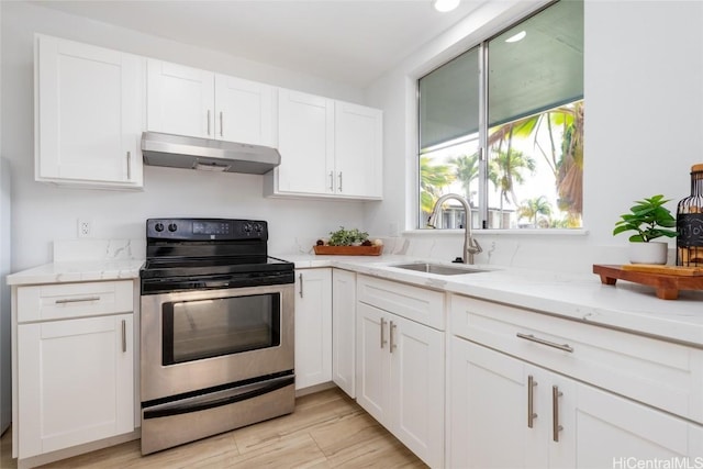 kitchen featuring electric stove, light wood-style flooring, white cabinets, a sink, and under cabinet range hood