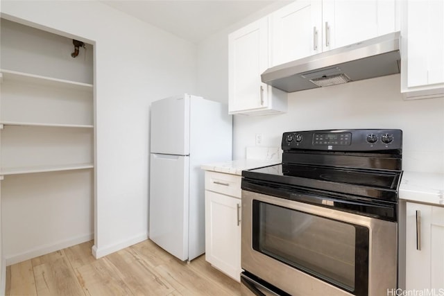 kitchen with light wood-style floors, freestanding refrigerator, stainless steel electric stove, under cabinet range hood, and white cabinetry