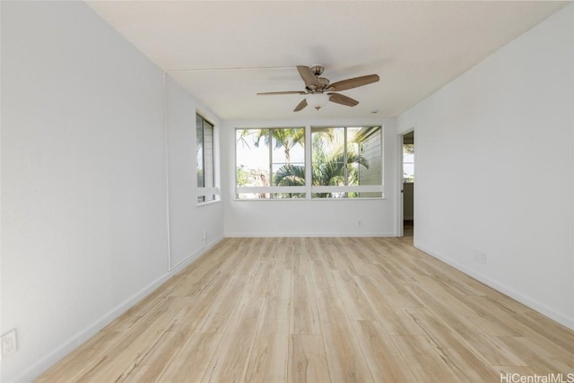 unfurnished room featuring baseboards, ceiling fan, and light wood finished floors