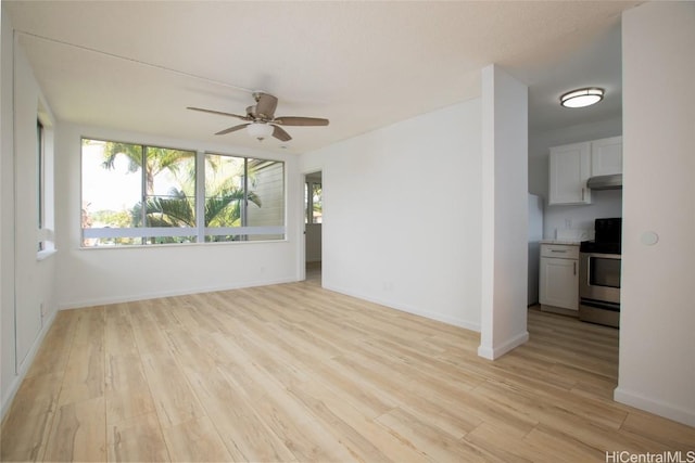 empty room featuring baseboards, a ceiling fan, and light wood-style floors