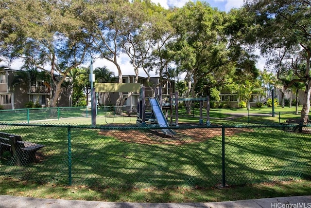 community jungle gym featuring a lawn and fence