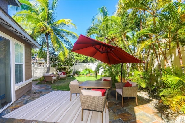 wooden terrace featuring a patio area, a fenced backyard, and an outdoor hangout area