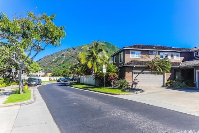 view of street with curbs, a mountain view, and sidewalks