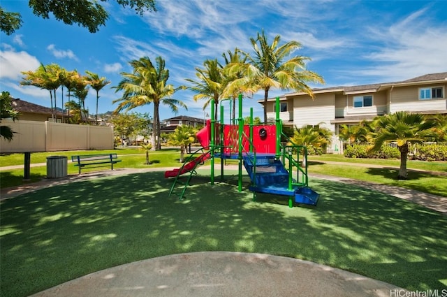 community play area with a lawn and fence