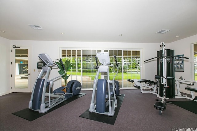 exercise room featuring visible vents, plenty of natural light, and baseboards