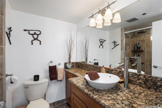 full bathroom with toilet, a stall shower, visible vents, and vanity