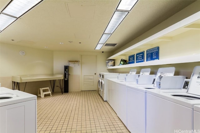 common laundry area with visible vents, washer and dryer, and light tile patterned flooring