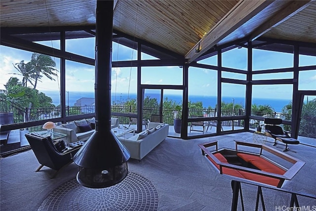 sunroom / solarium featuring a healthy amount of sunlight, wooden ceiling, and vaulted ceiling with beams