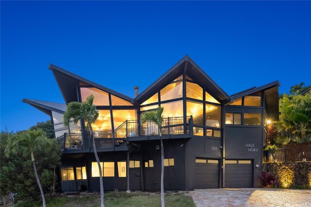 1826 Laukahi St, Honolulu, HI 96821 - back of house at night with a balcony, a garage, and driveway