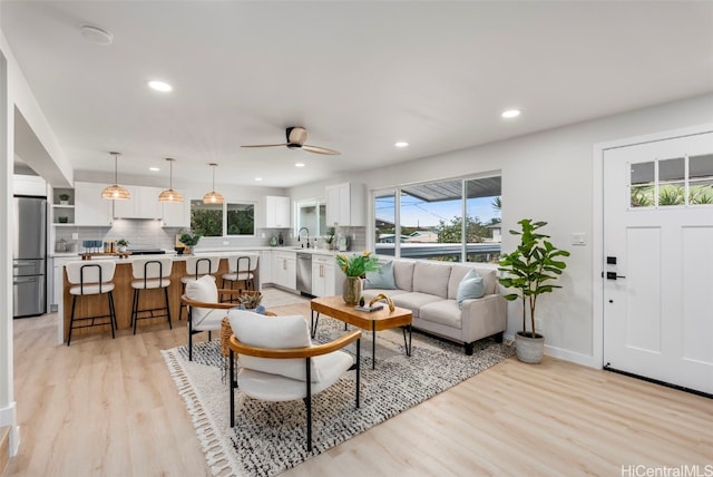 living area with light wood finished floors, baseboards, a ceiling fan, and recessed lighting