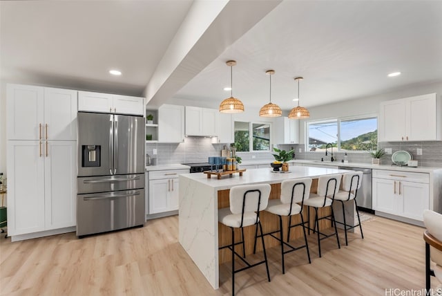 kitchen featuring stainless steel appliances, white cabinets, and light countertops