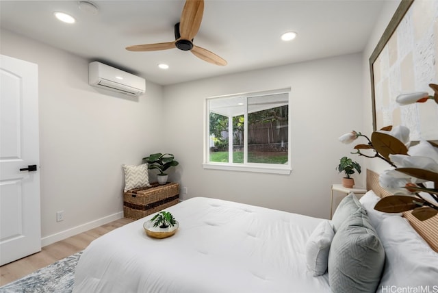 bedroom featuring recessed lighting, light wood finished floors, and a wall mounted AC