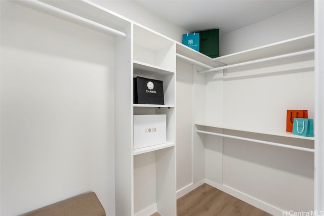 walk in closet with light wood-style floors