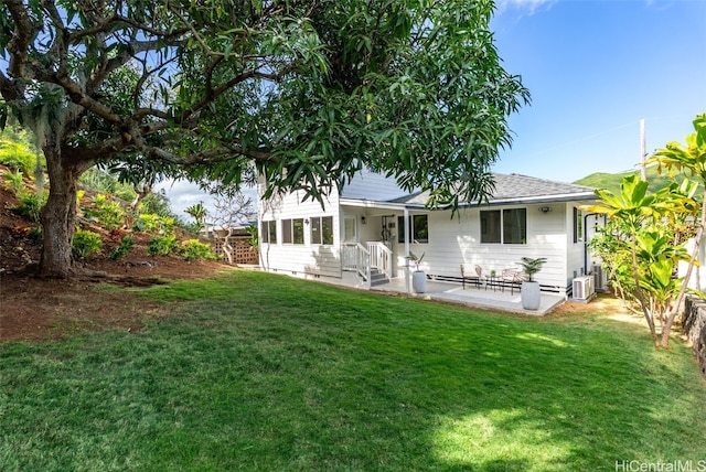 rear view of house with a yard and fence