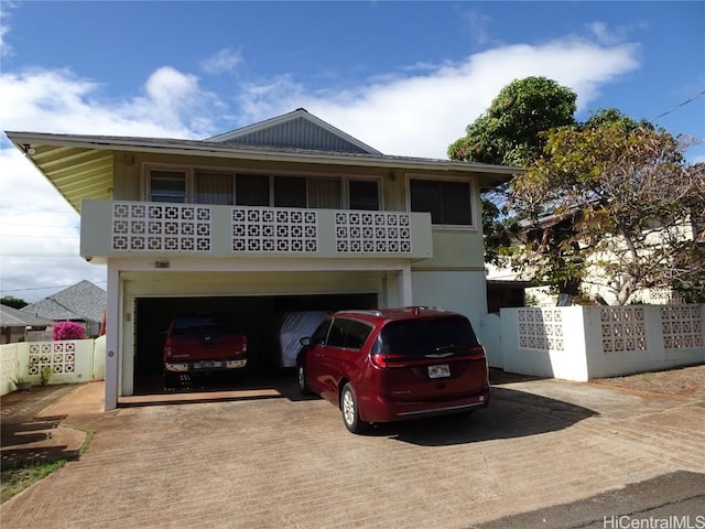 view of front of home featuring a garage, fence, and concrete driveway