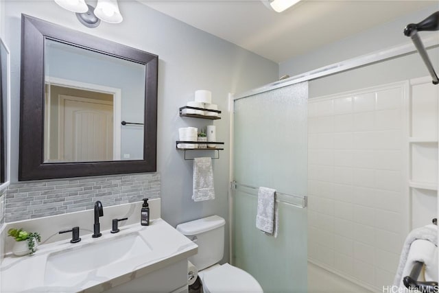 bathroom with toilet, tasteful backsplash, vanity, and a stall shower