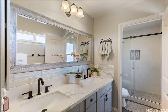 bathroom featuring a sink, toilet, a shower stall, and double vanity