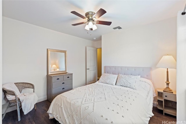 bedroom featuring visible vents, baseboards, a ceiling fan, and dark wood finished floors