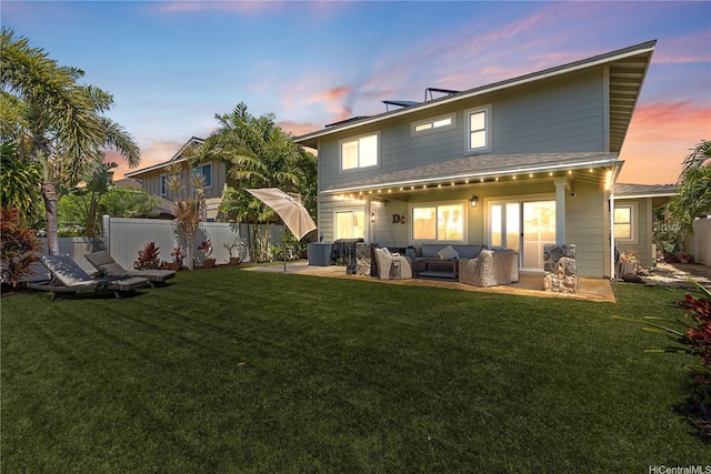 rear view of house with fence, a lawn, and an outdoor hangout area
