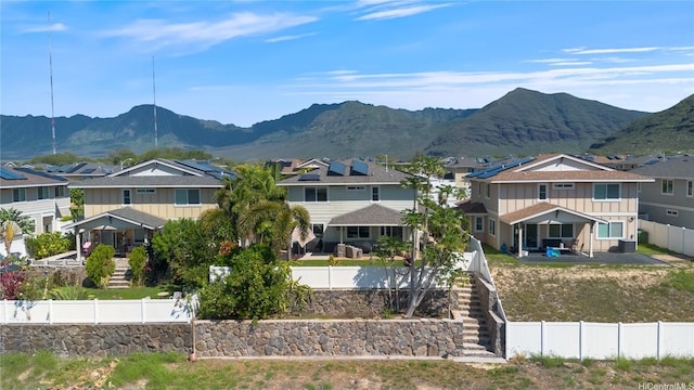 exterior space featuring a mountain view, a fenced backyard, stairway, and a residential view