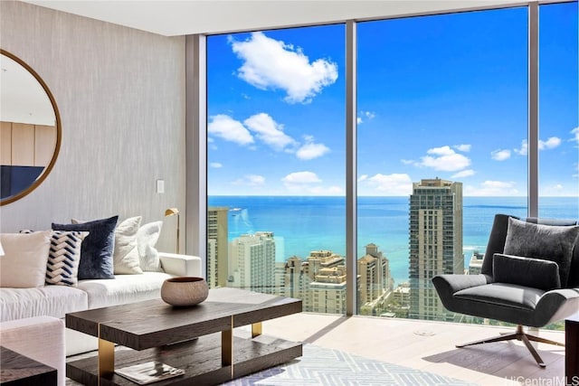 living area featuring expansive windows, a water view, a city view, and wood finished floors