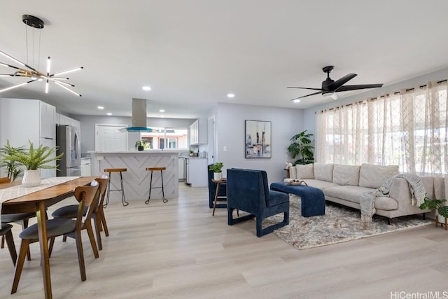 living room featuring ceiling fan, light wood finished floors, and recessed lighting