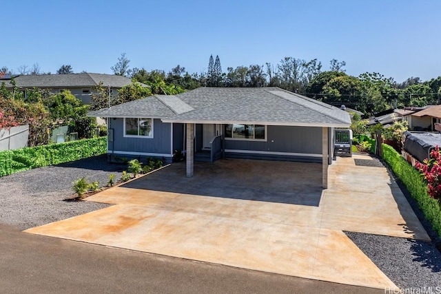 ranch-style home featuring fence, concrete driveway, and roof with shingles