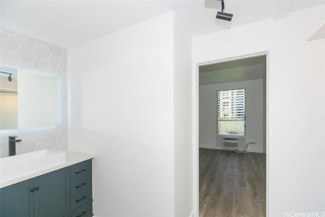 bathroom featuring a wall unit AC, vanity, and wood finished floors